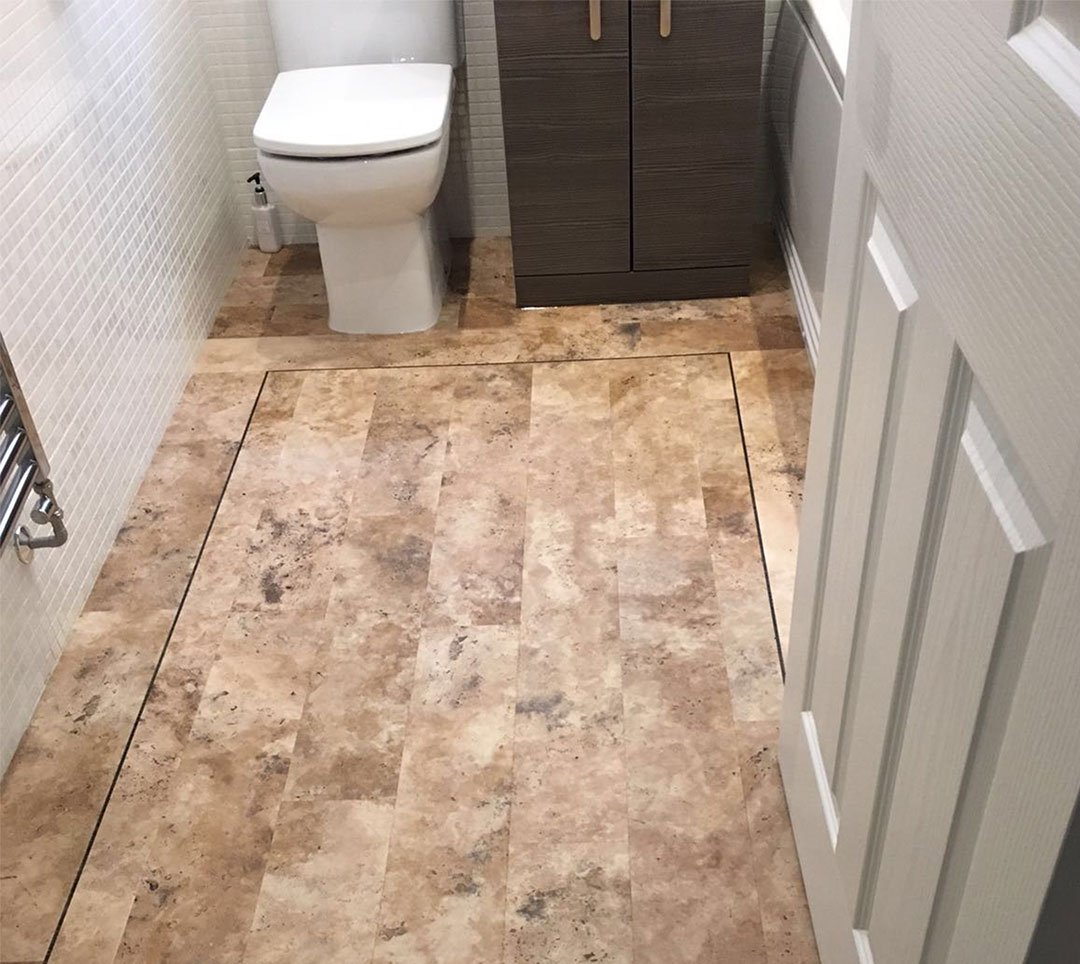 Stone-effect vinyl bathroom floor with a dark inlaid border